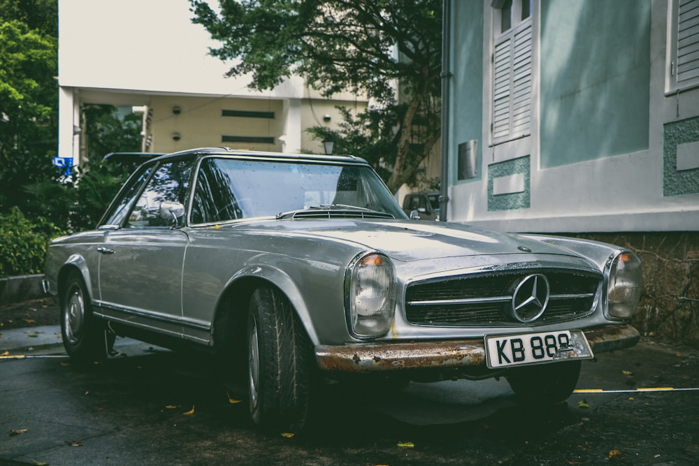 Mercedes-Benz coupé gris fuera de la casa