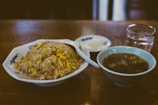 A serene table setting with steamed jasmine rice, stir-fried greens, and a cup of green tea.