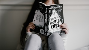 woman reading book while seating