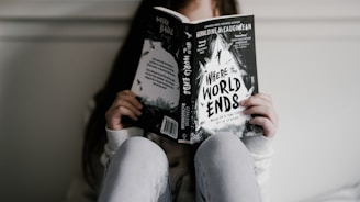 woman reading book while seating