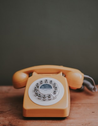 brown rotary dial telephone in gray painted room