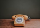 brown rotary dial telephone in gray painted room