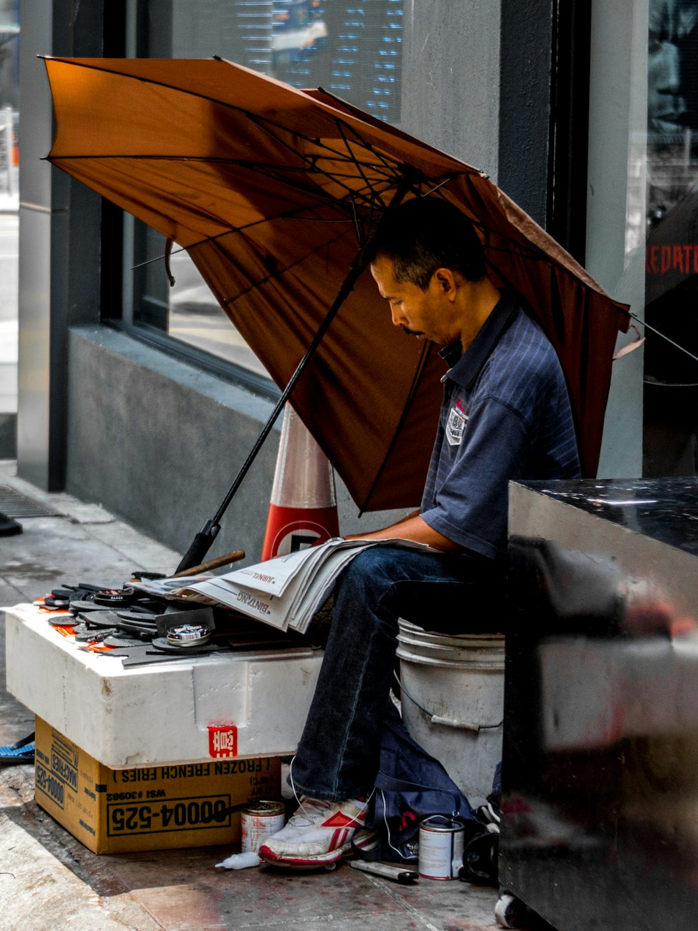 man sitting under brown umbrella