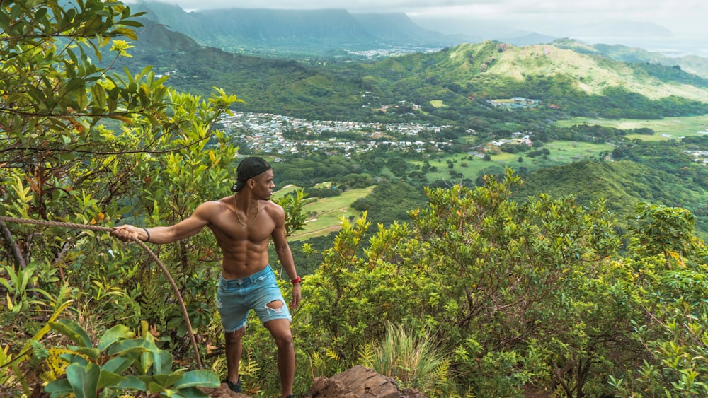 man holding on rope looking at mountain