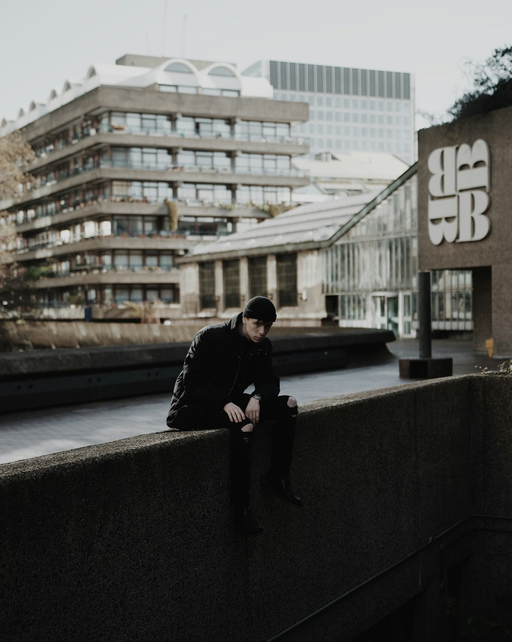 man sitting on concrete edge during daytime