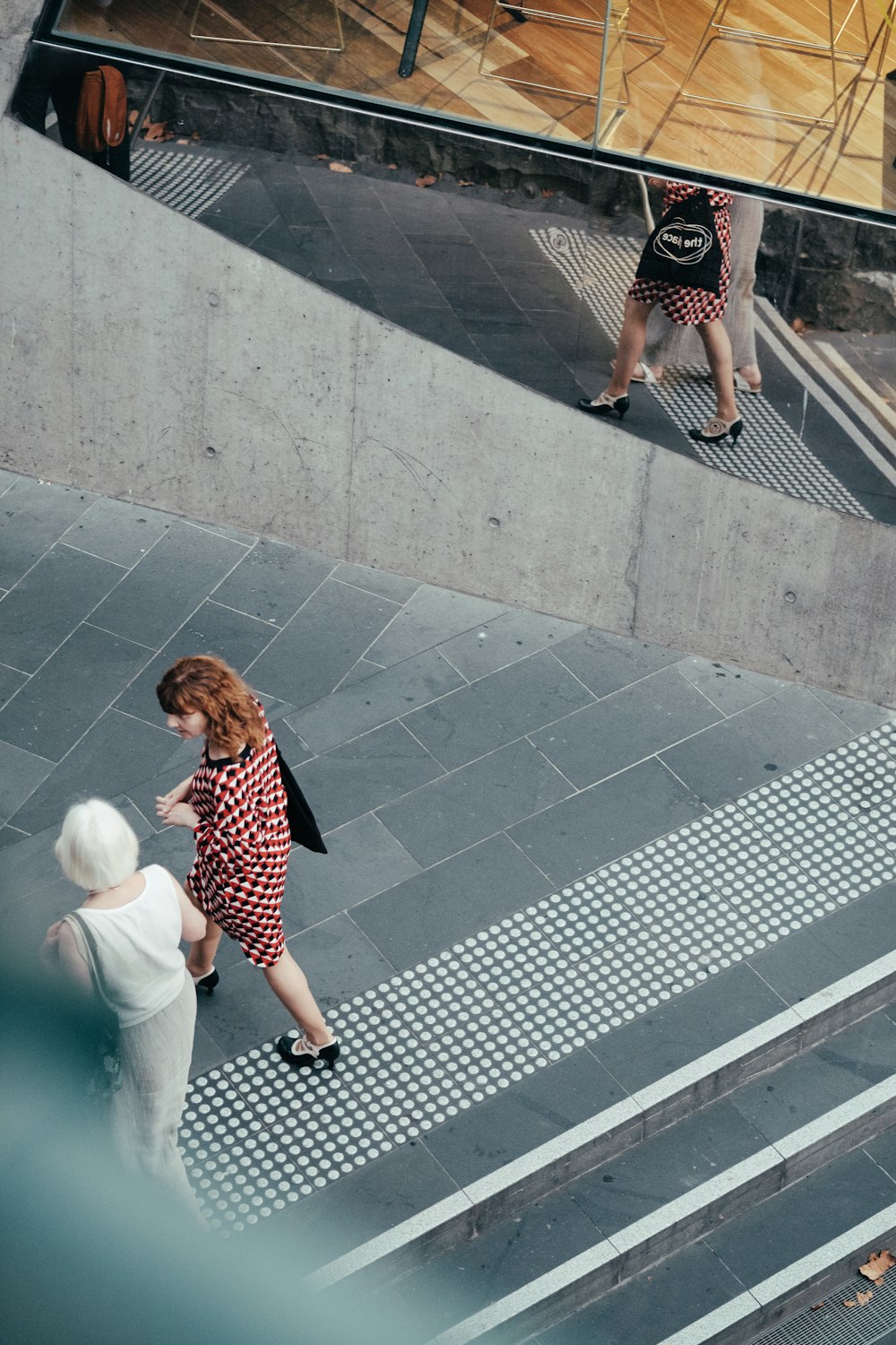 people walking on street near mirrored wall