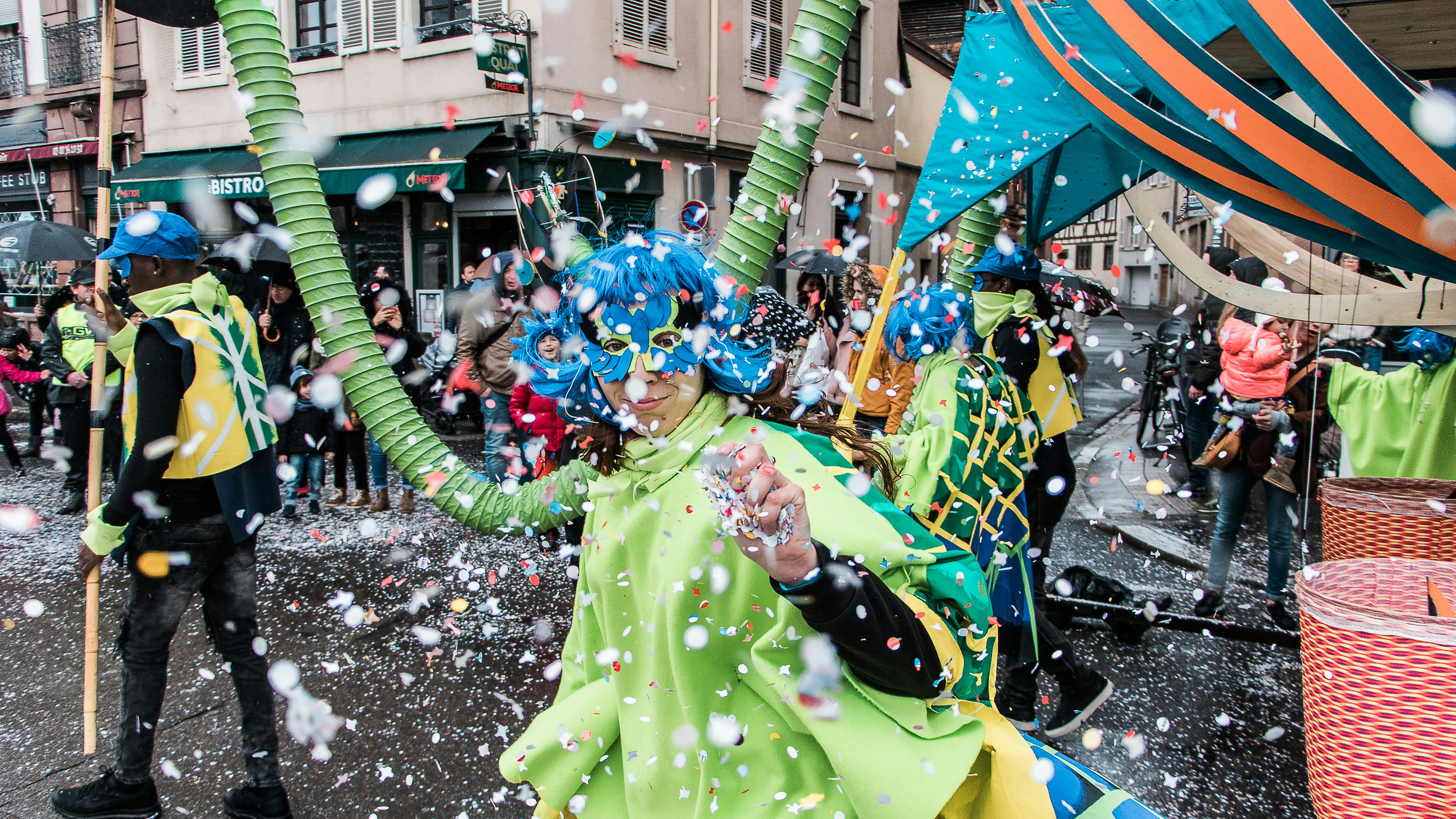Buntes Konfetti beim Karnevalszug, jubelnde Menschen in Kostümen