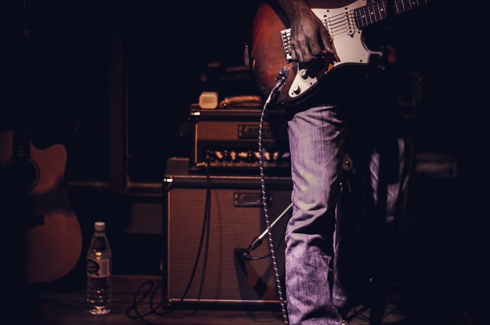 man playing guitar inside dark room