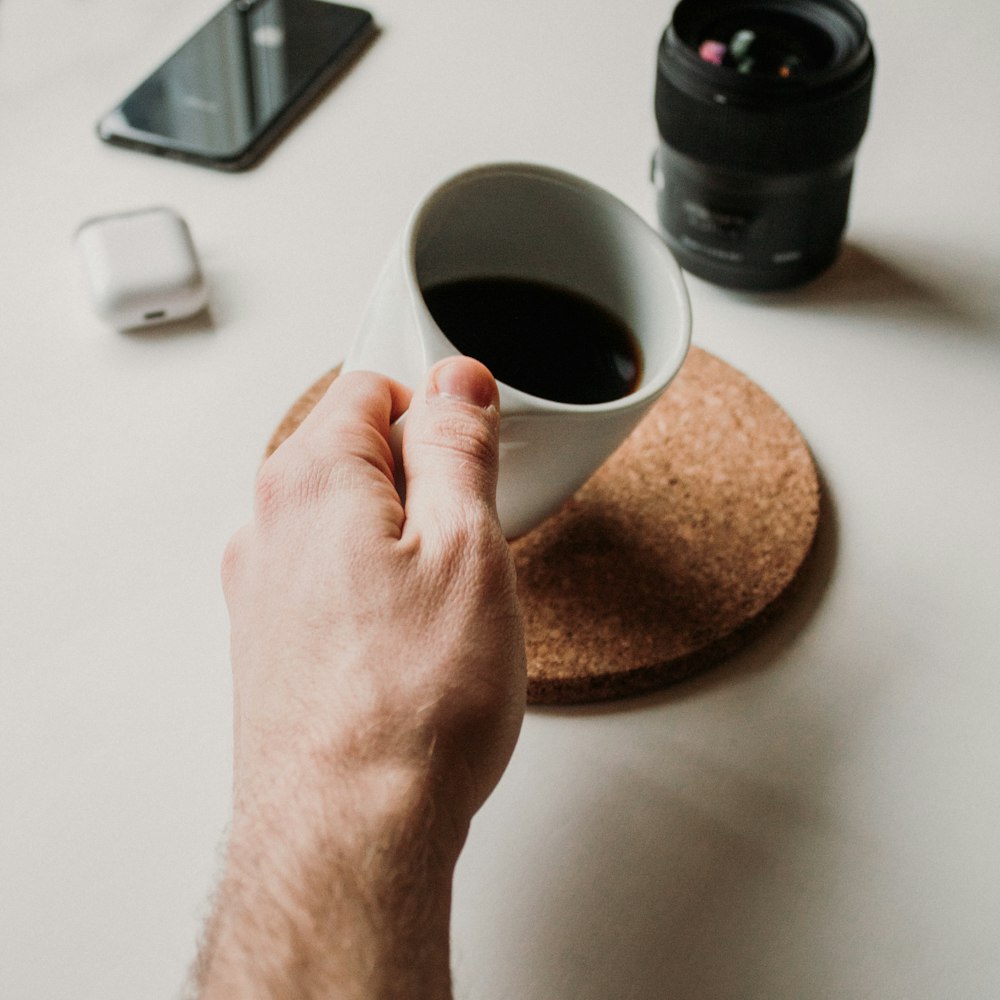 person holding white ceramic mug