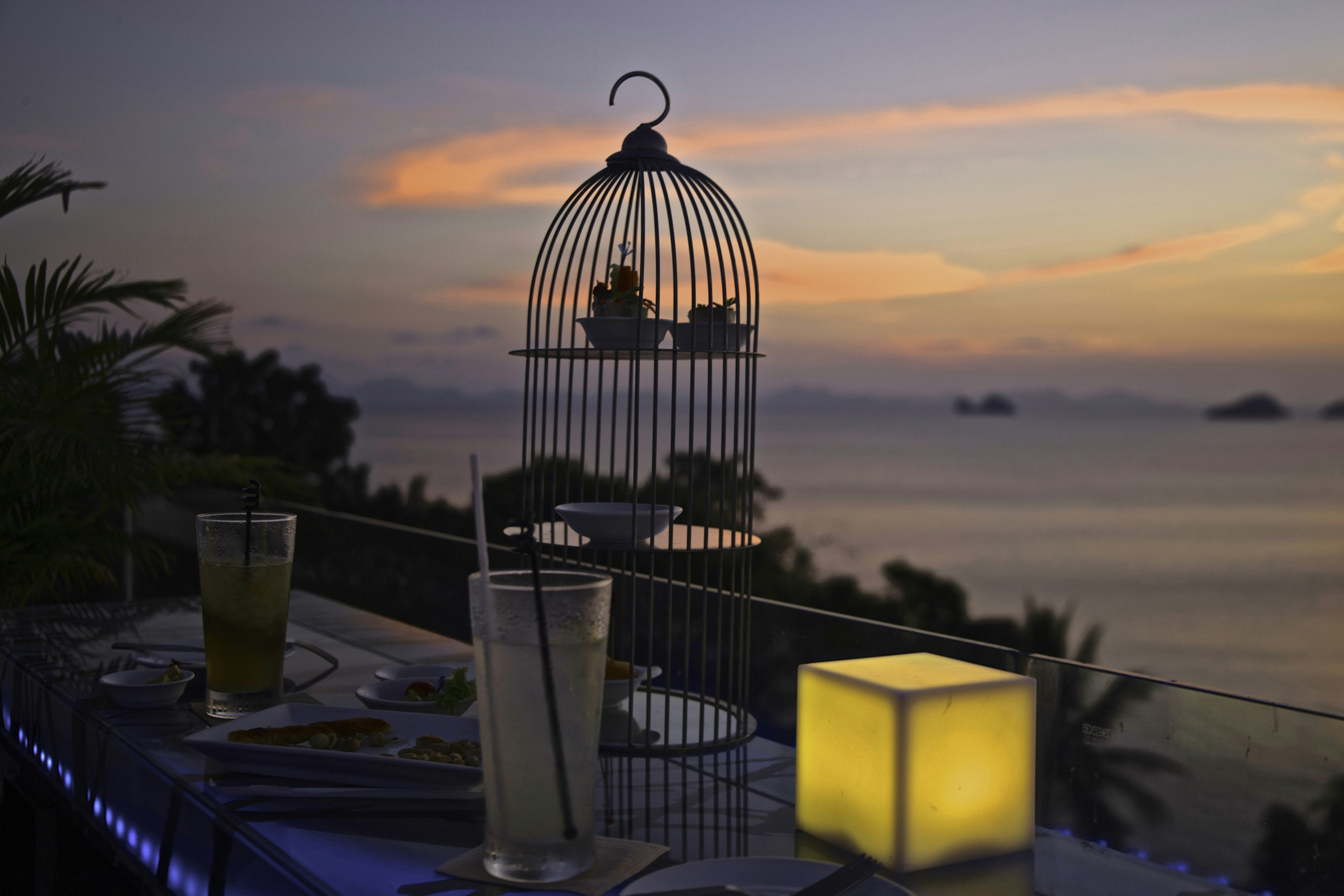 Romantic sunset dinner on clifftop overlooking Cape Town coastline with champagne glasses
