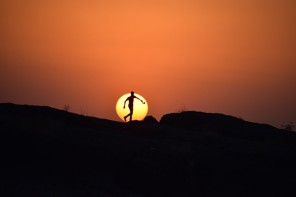 silhouette of man on hill