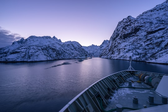 low-light photo of boat on calm body of water in Trollfjorden Norway