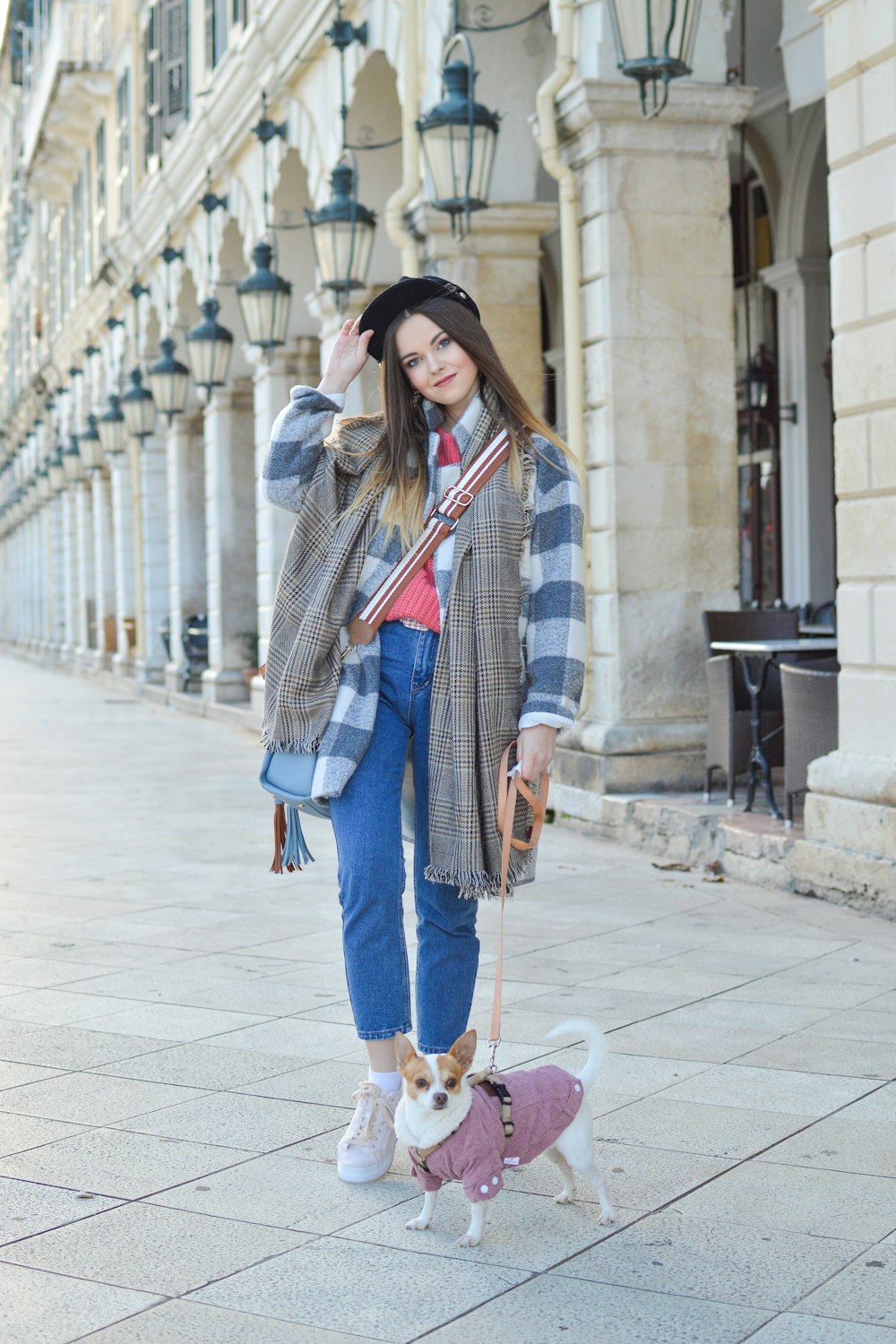 woman and puppy standing beside building