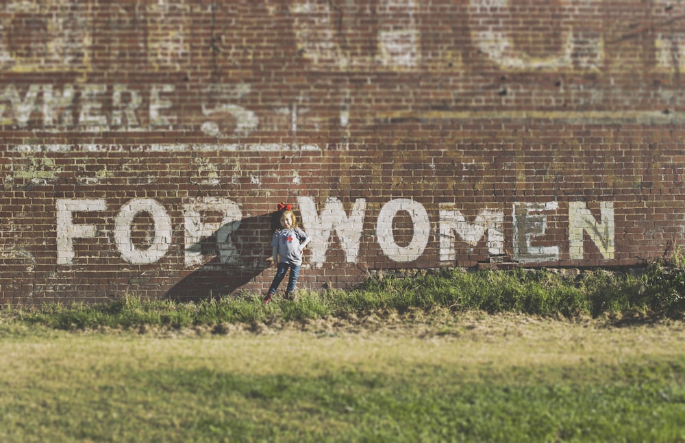 girl standing near brown building during daytime