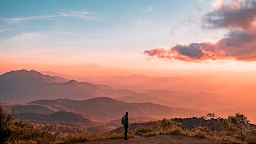 Randonneuse face aux montagnes au coucher du soleil