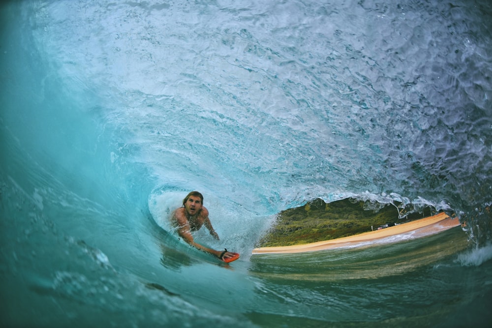 Mann surft in Welle auf dem Wasser