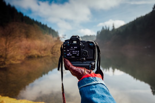 person holding camera facing a river in Dalby Forest United Kingdom