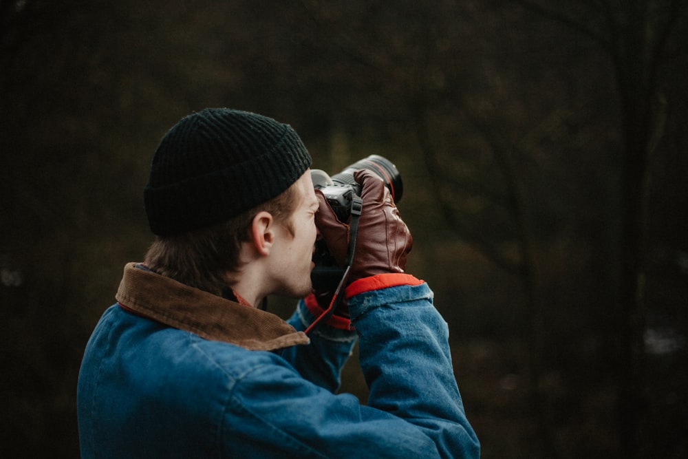 man taking picture using DSLR camera during daytime