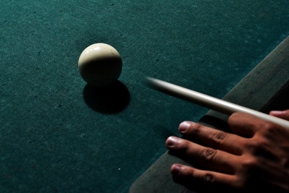 person holding brown cue stick