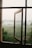an open window with a view of a foggy field