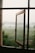 an open window with a view of a foggy field