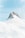 A snow-covered mountain peak rises prominently against a clear blue sky. The rugged rock formation of the peak contrasts with the smooth, gently sloping snow that covers the surrounding landscape.