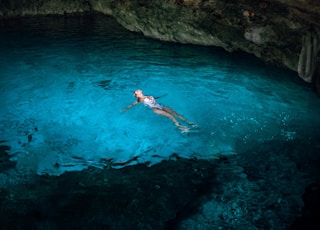 woman swimming under cave