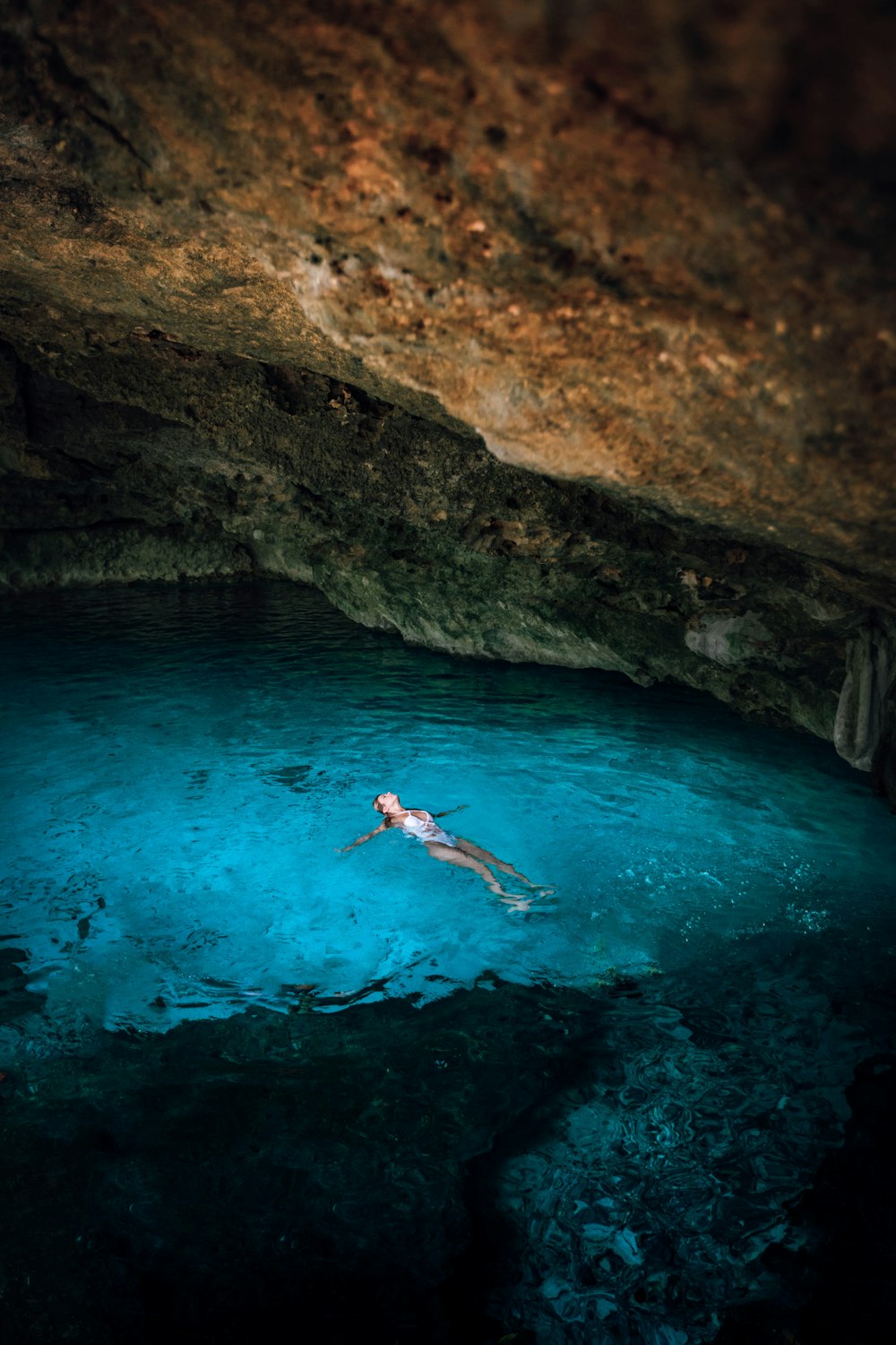 woman swimming under cave