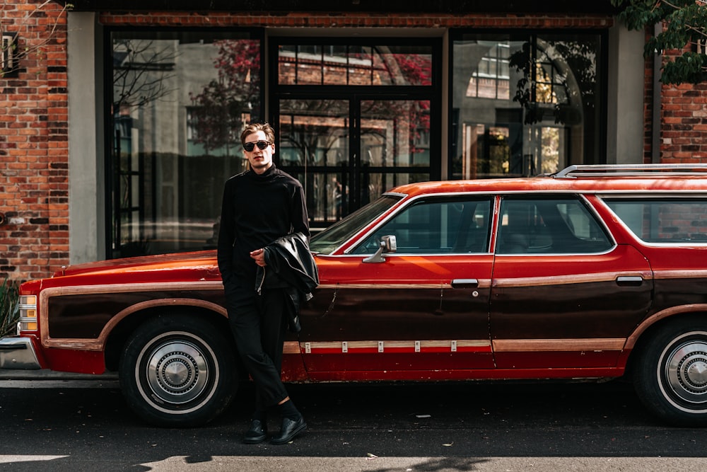 man leaning on station wagon