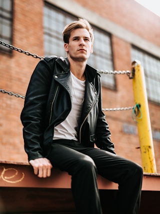 man sitting on dock near building