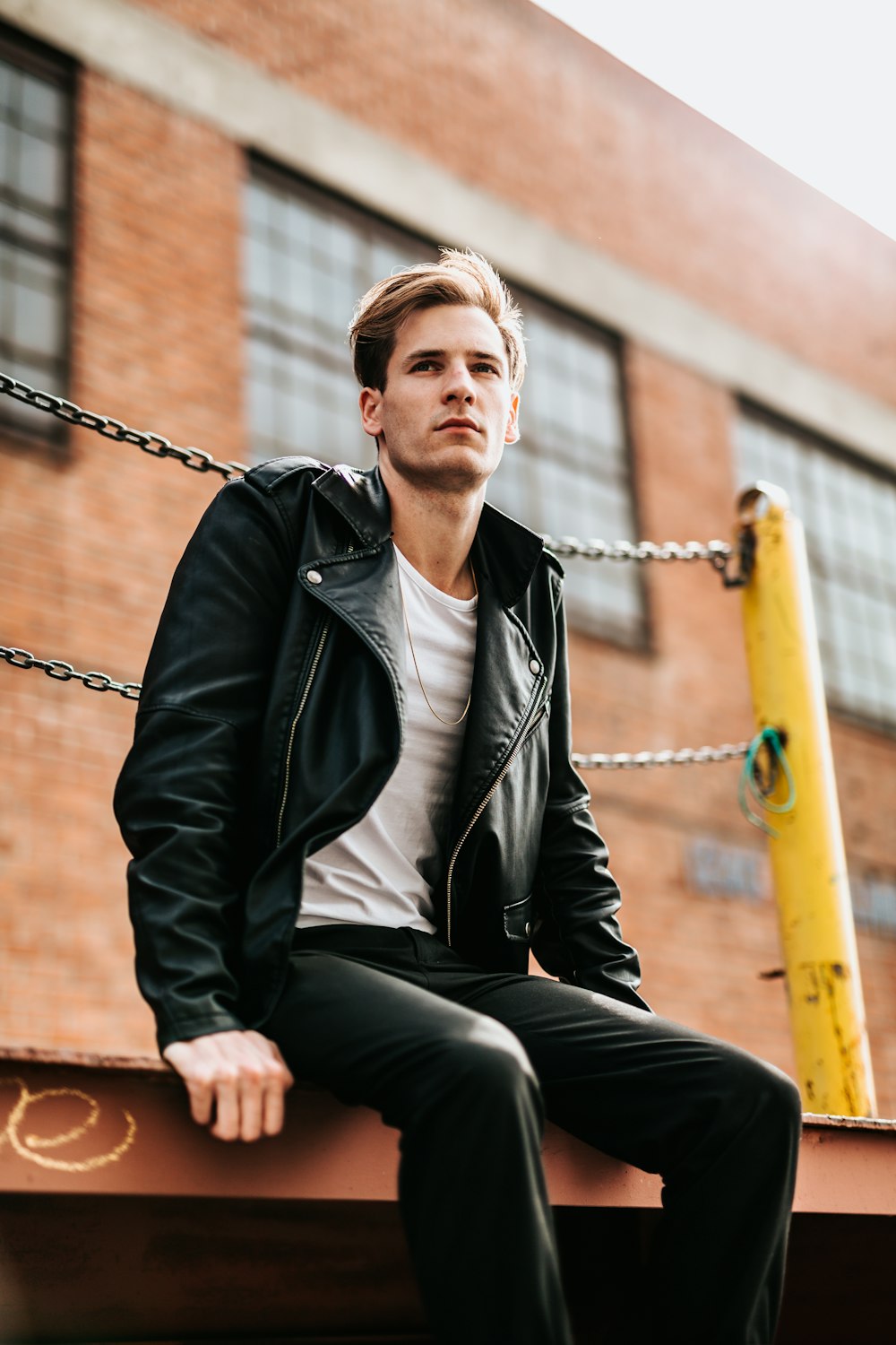 man sitting on dock near building