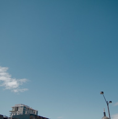 gray building under blue sky and white clouds during daytime