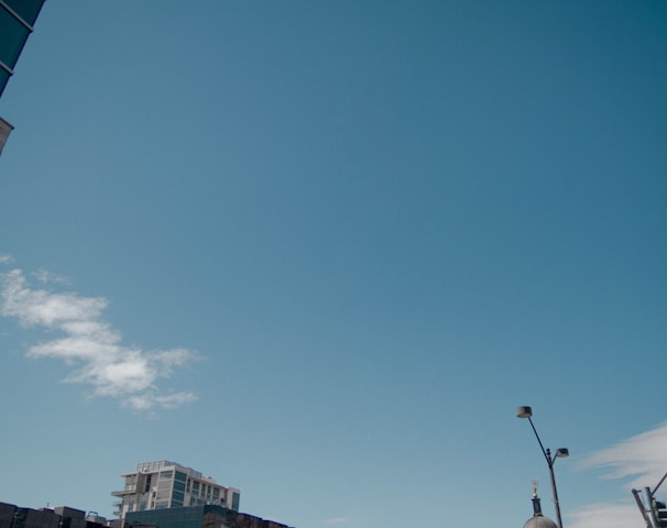 gray building under blue sky and white clouds during daytime