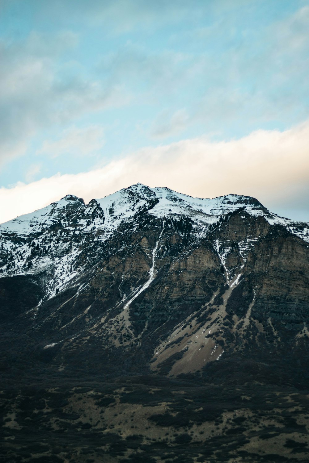 montanha coberta de neve sob céu nublado