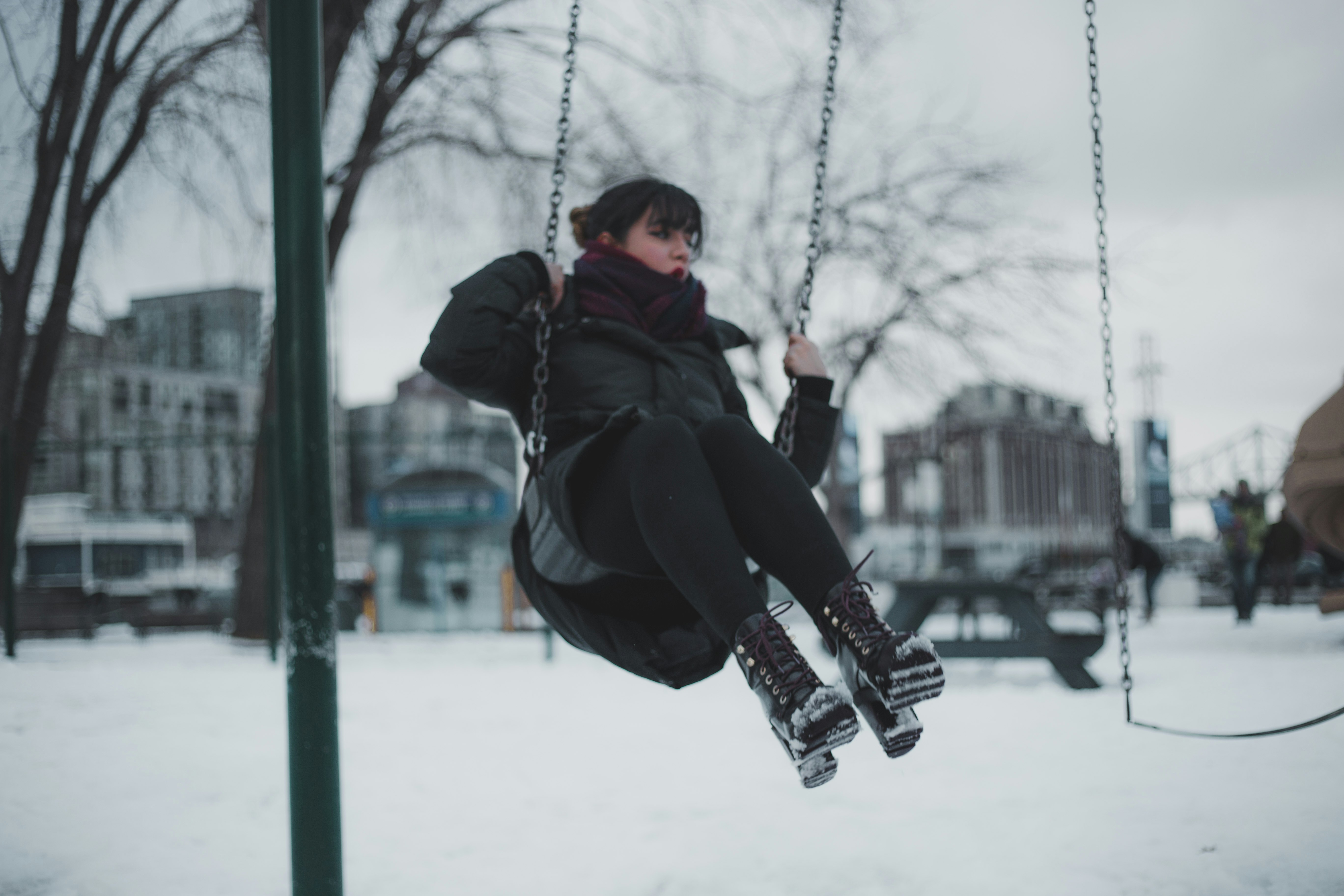 shallow focus photo of woman riding swing