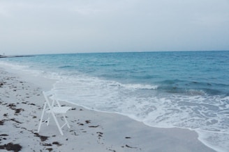 A serene beach scene with a coach and student discussing debate points.