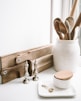 brown wooden spoons on ceramic canister on white top surface