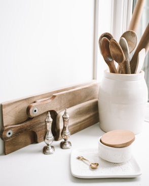 brown wooden spoons on ceramic canister on white top surface