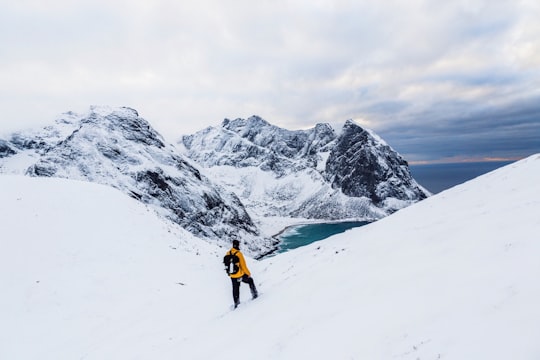 man wearing yellow jacket standing on white snowland at daytime in Ryten Norway