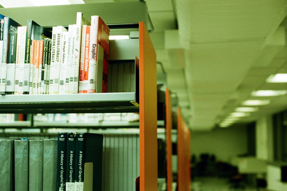 pile of books on brown wooden shelf