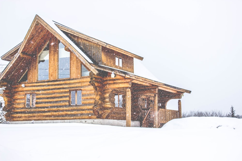 maison en bois marron recouverte de neige