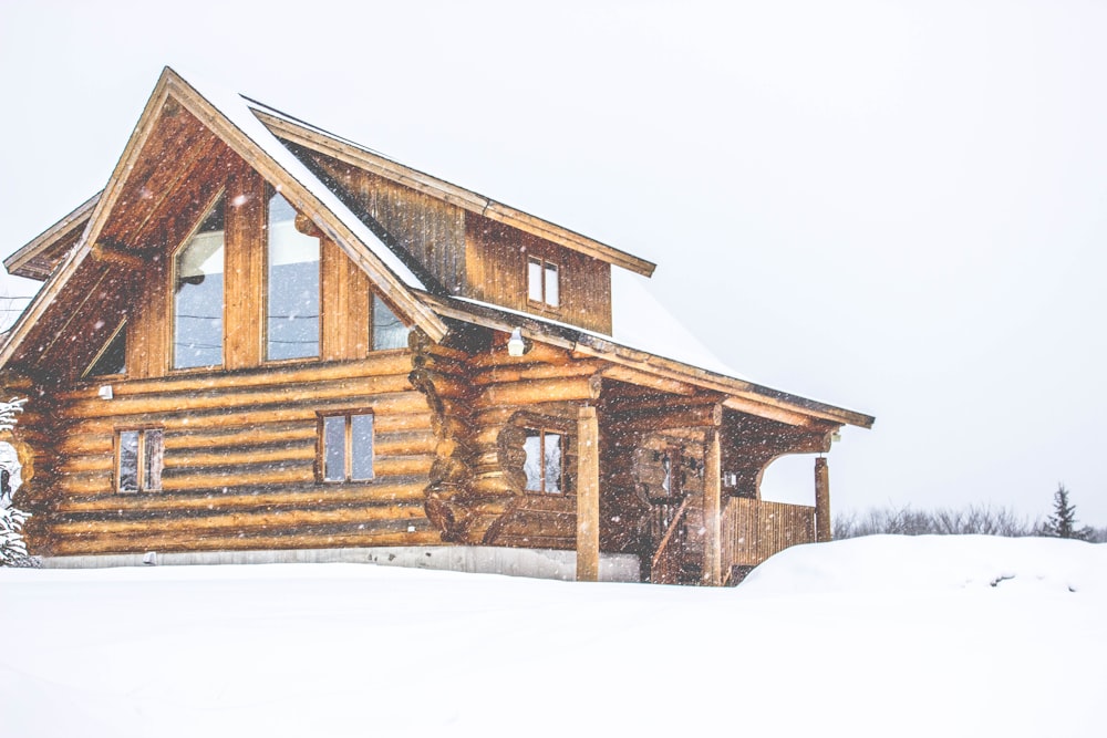 雪に覆われた茶色い木造家屋