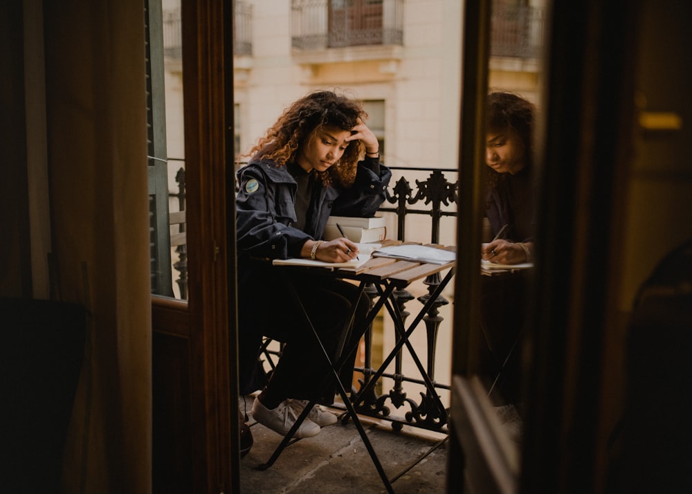 woman wearing black jacket holding pen