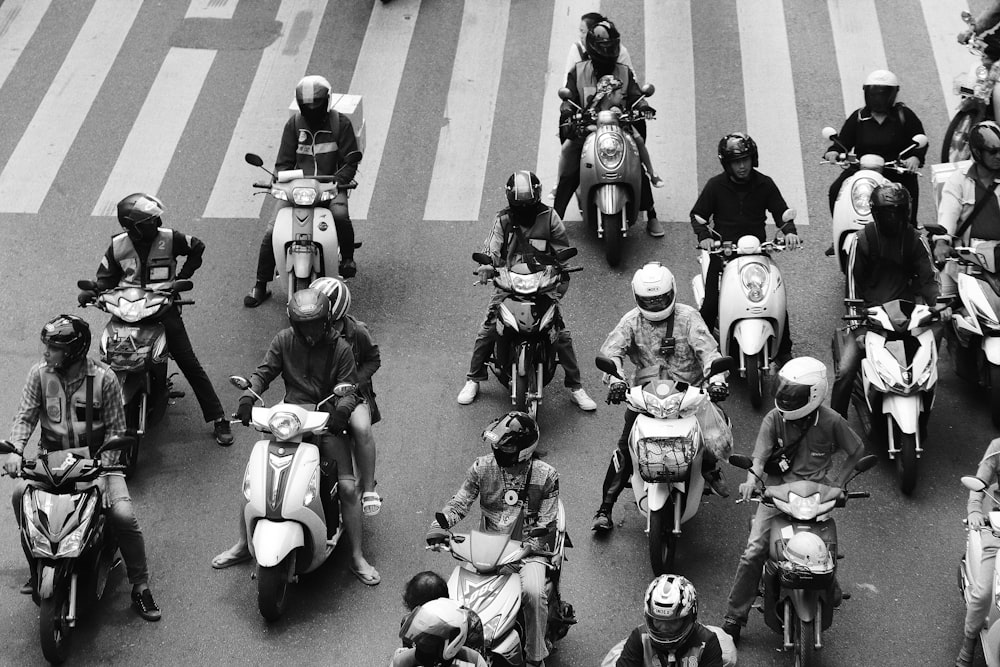 people ride-on motorcycles at the road grayscale photography