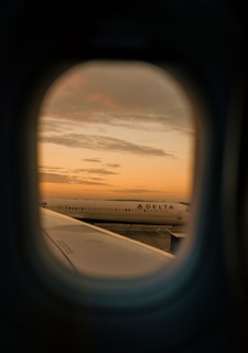 A breathtaking view of a delta air airplane taking off at sunset.