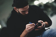 Technician carefully repairing a security camera with precision tools.