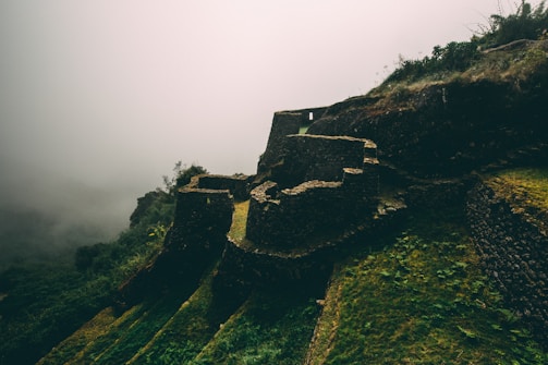 Fog rolling over cracked stone ruins in a forgotten onsen.