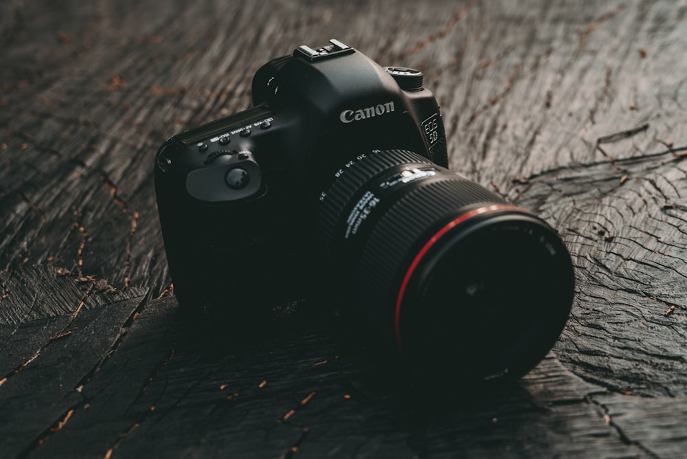 Appareil photo reflex numérique Canon EOS noir sur planche en bois marron