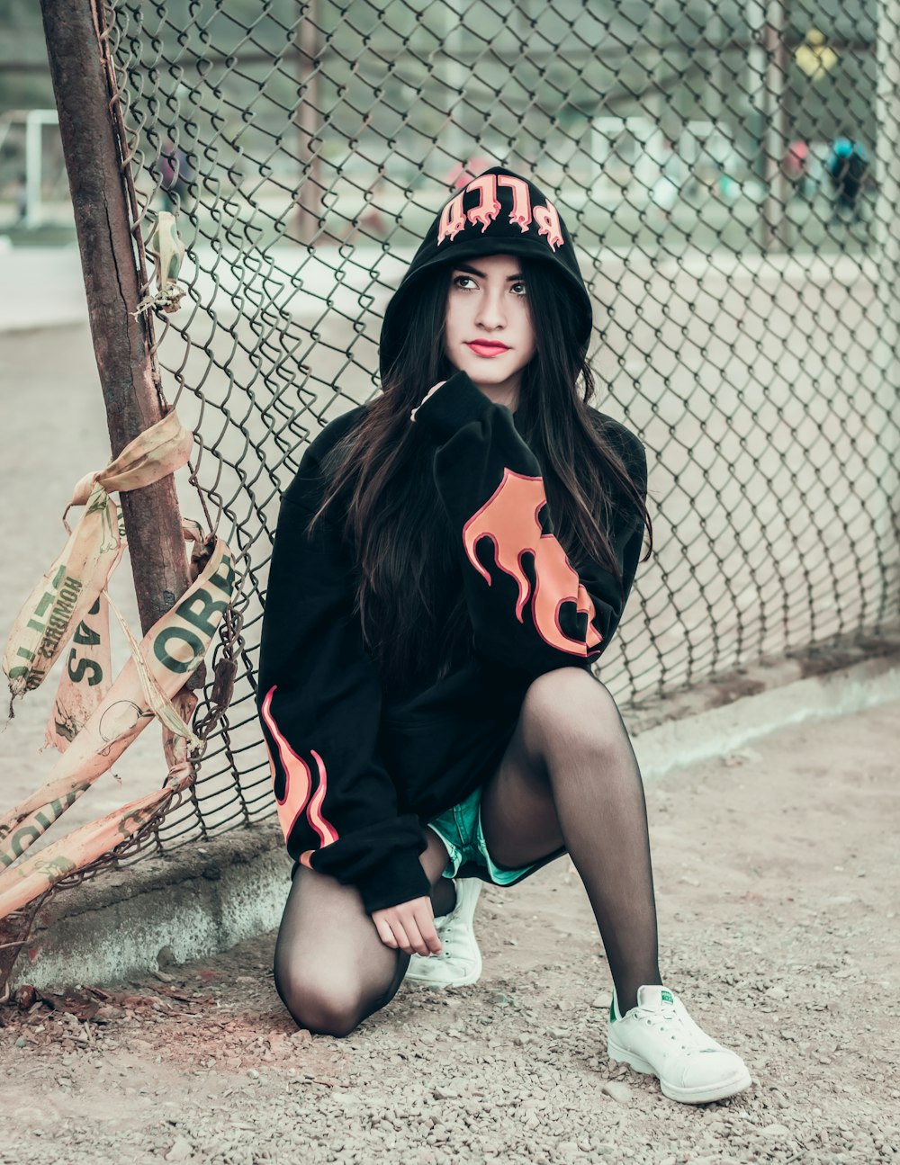 woman kneeling near fence