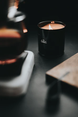 Warm candlelight casting gentle shadows over a bundle of self-care products.